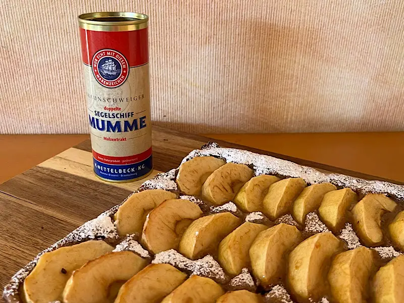 Eine Dose Braunschweiger Mumme neben einem Apfelkuchen